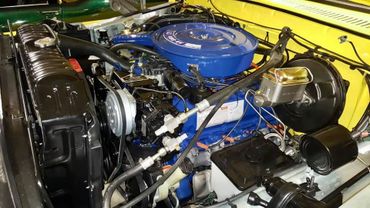 Clean and detailed view of a classic car engine with a blue air filter.