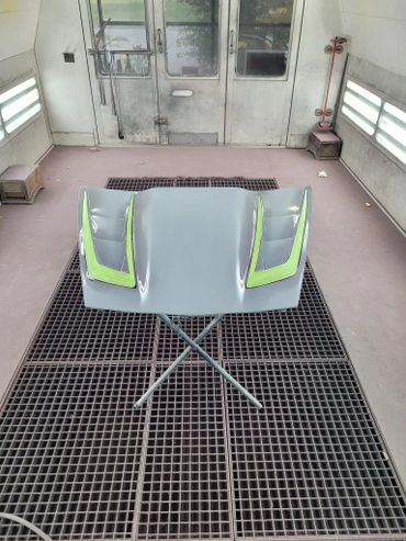 Car hood with vents in a paint booth.