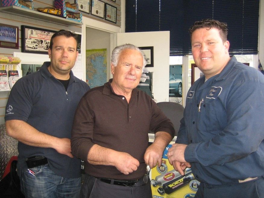 father and 2 sons in a mechanics shop
