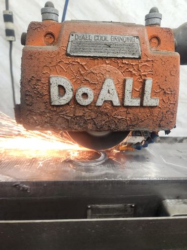 DoAll surface grinder being used to grind a piece of steel.