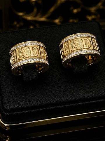Pair of luxurious gold rings engraved with 'MADE' and encrusted with diamonds.