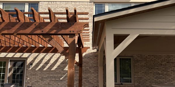 Wooden pergola and house exterior with brick walls.