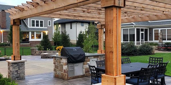 Outdoor patio with pergola and barbecue grill.