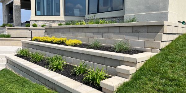 Modern tiered garden with stone retaining walls and plants.