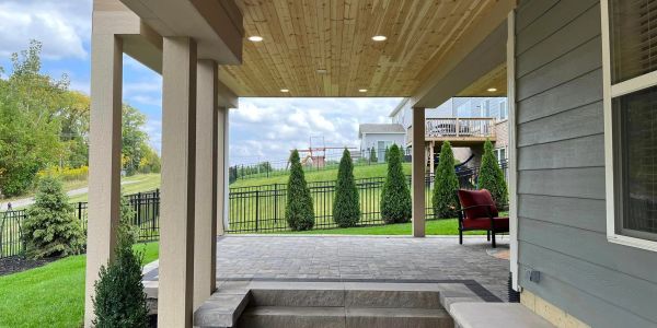 Covered outdoor patio with greenery and seating.