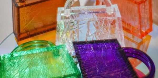 Colorful translucent acrylic handbags in various shapes and sizes.