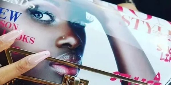 Close-up of a magazine cover featuring a woman's face and manicured nails.