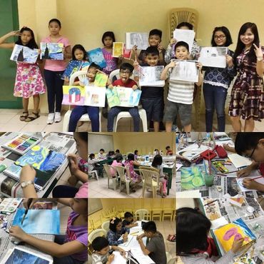 Children proudly display their colorful artwork in a classroom setting.