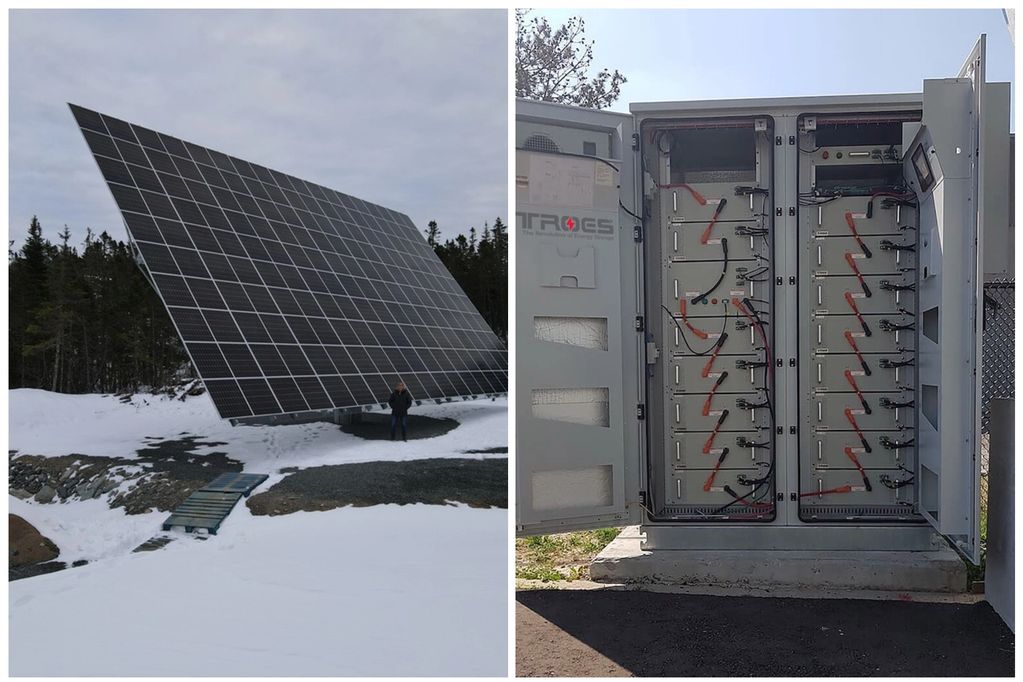 large two axis solar tracker with snow on ground.  Battery bank in an outdoor enclosure, doors open.