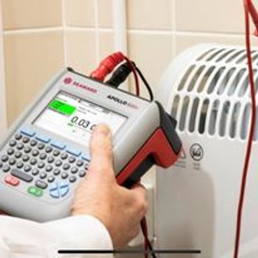 Hand holding a device testing electrical appliance safety. Seawood 500 pat testing machine.