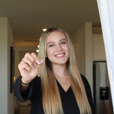 Smiling woman holding a key.