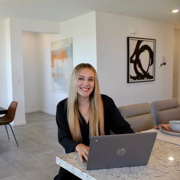 Young woman smiling while working on a laptop.