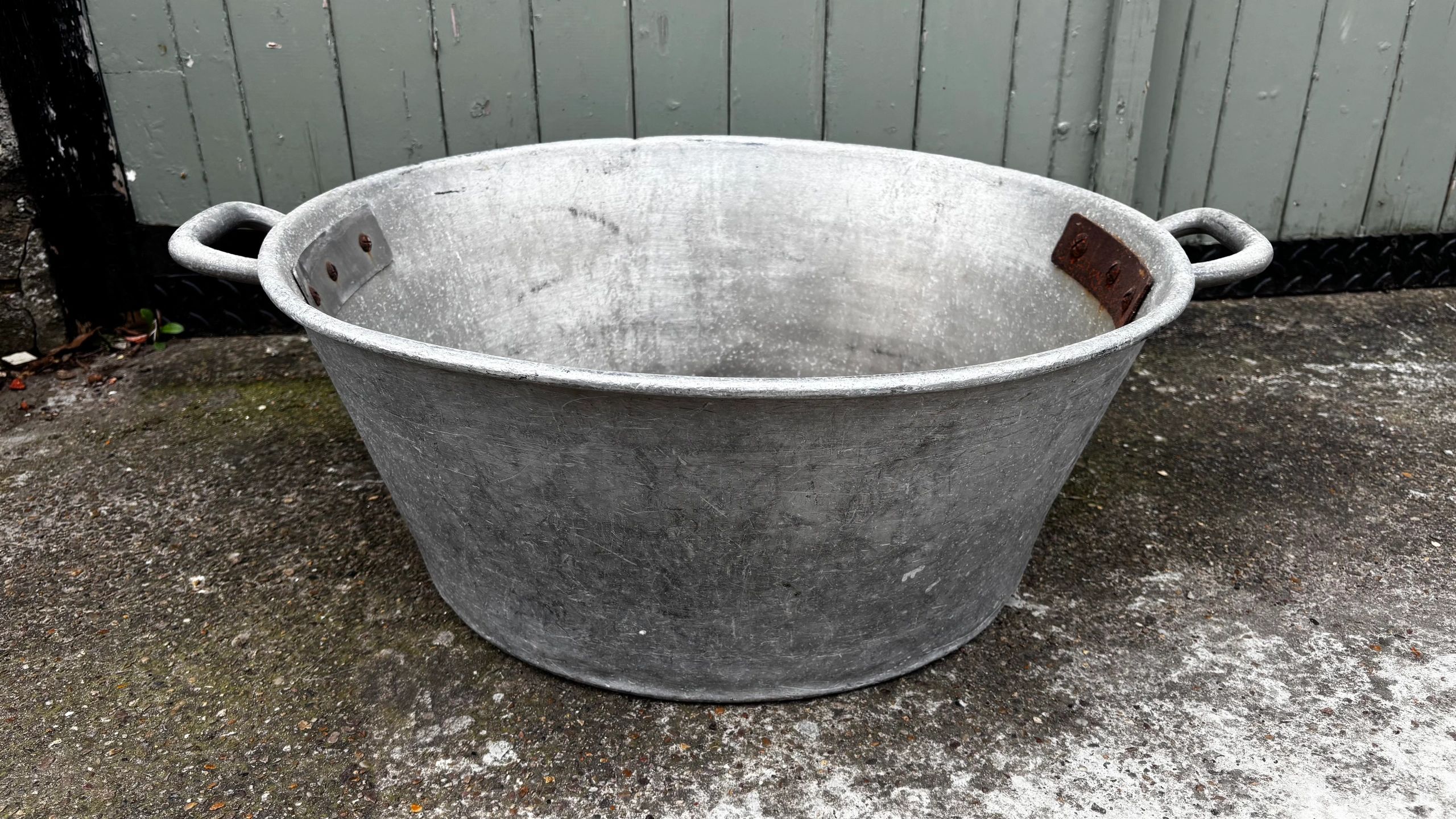 Large metal basin on a concrete surface.