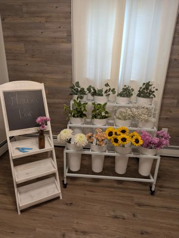 Flower bar setup with potted plants and flowers.