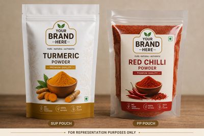 Two spice pouches labeled turmeric powder and red chilli powder on a wooden surface.