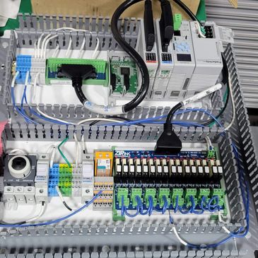 Organized electrical control panel with wiring and components inside a metal enclosure.