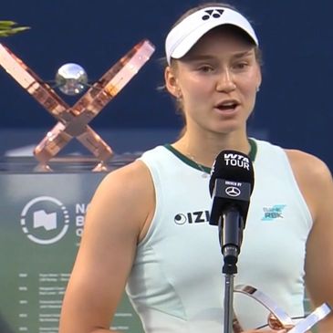 Female tennis player giving a post-match interview holding a trophy.