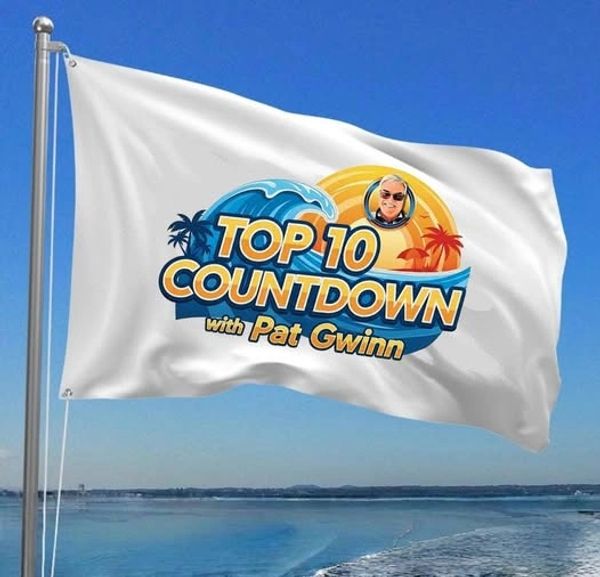 Flag with "Top 10 Countdown with Pat Gwinn" logo flying by the ocean.