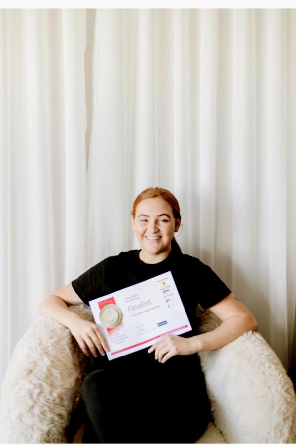 Happy woman holding a finalist certificate.