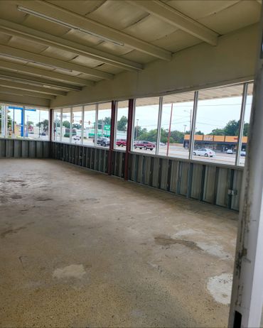Empty commercial space with large windows along the street.
