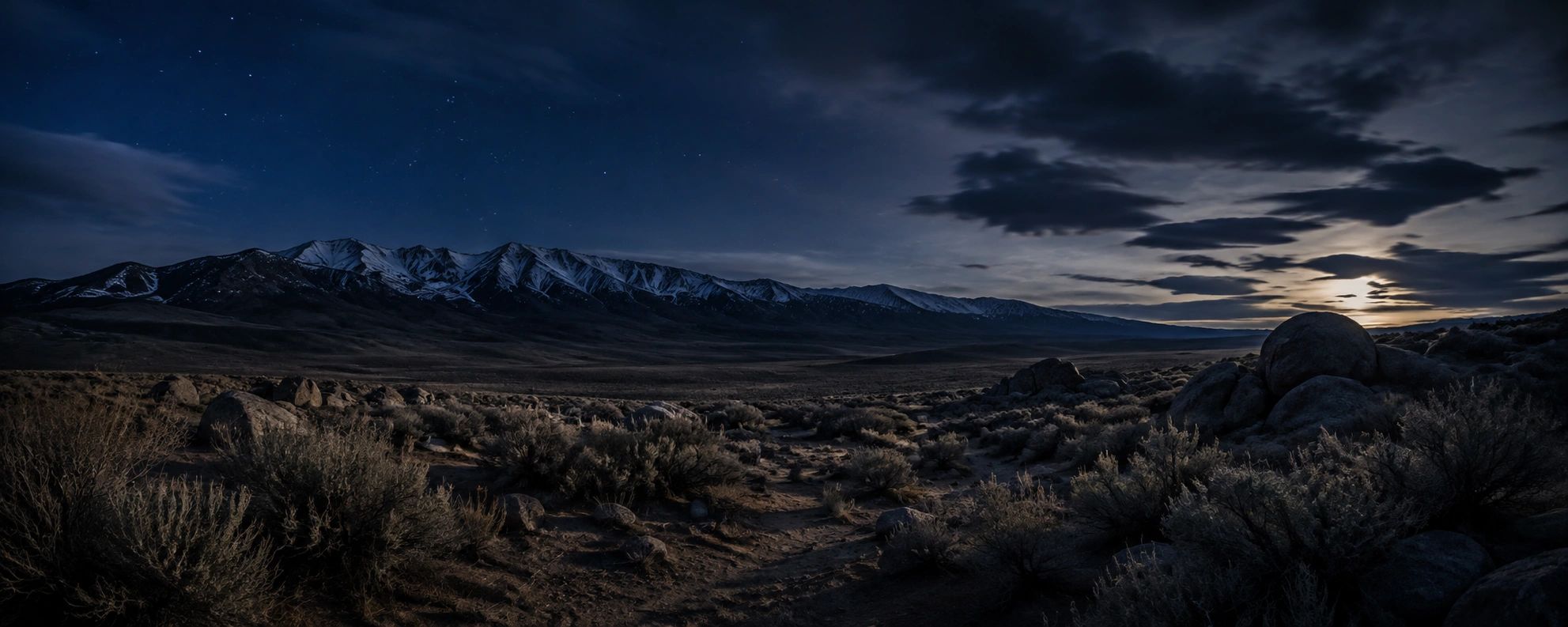 Night landscape with snowy mountains and starry sky.