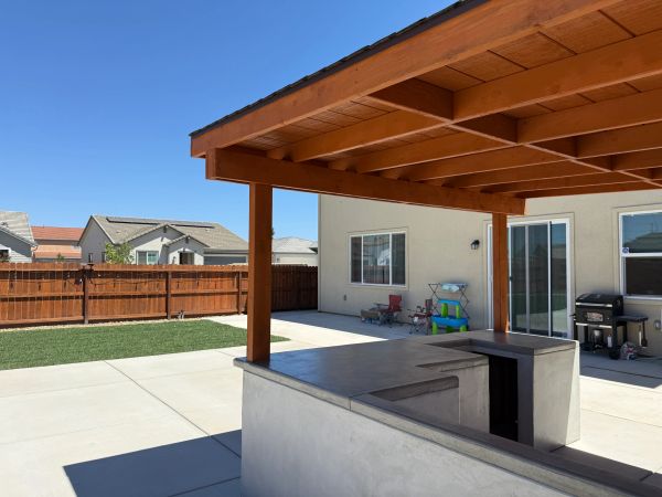 Backyard patio with pergola and outdoor kitchen.