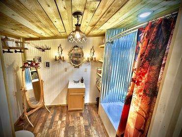 Rustic bathroom with wooden ceiling and antler-themed decor.