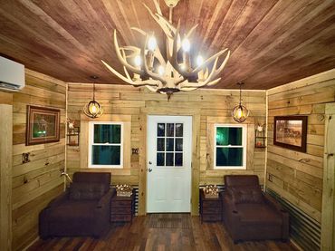 Cozy rustic room with antler chandelier and leather recliners.