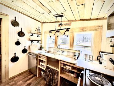 Rustic kitchen with cast iron pans and wooden accents.