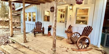 Rustic porch with wooden rocking chairs and welcoming decor.