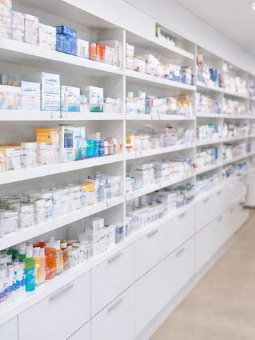 Pharmacy shelves filled with various medications and pharmaceutical products.