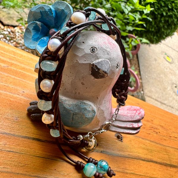Beaded necklace draped on a bird figurine.