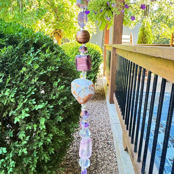 Decorative hanging beads near garden and porch railing.