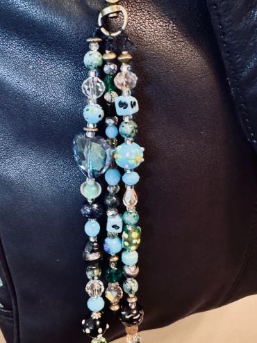 Colorful beaded keychain hanging on a leather surface.
