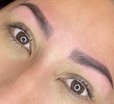 Close-up of freshly microbladed eyebrows on a person's face.