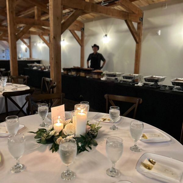 Candlelit centerpiece on a round table at an event.