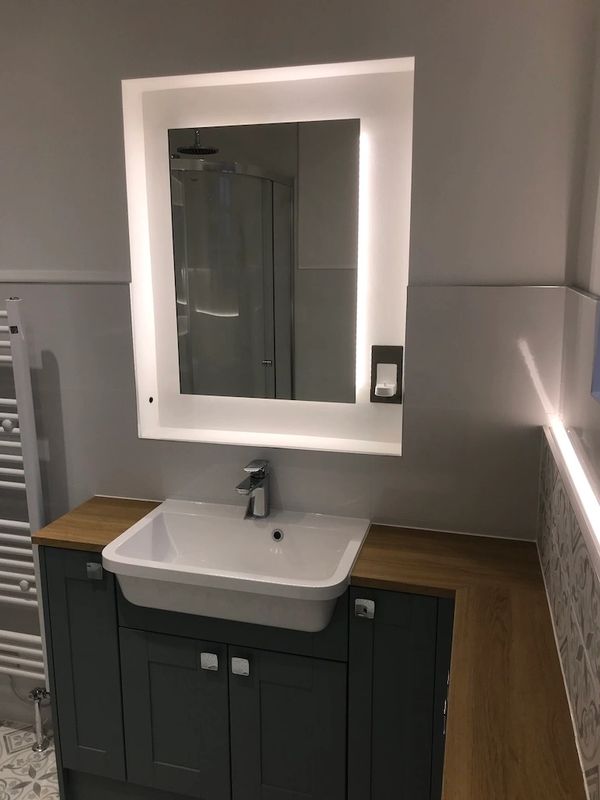 Mirror recess with IR hand sensor powering light control, enhancing mirror recess with lighting.