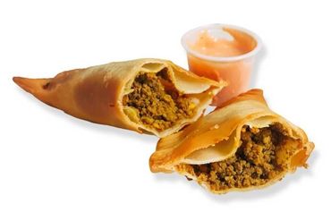 Beef empanada cut in half to show the inside with mayo-ketchup sauce on the side