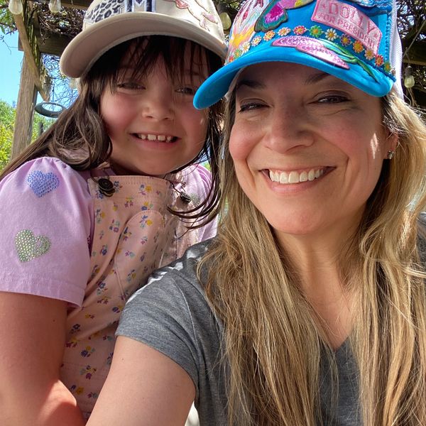 Smiling woman and child wearing colorful hats.