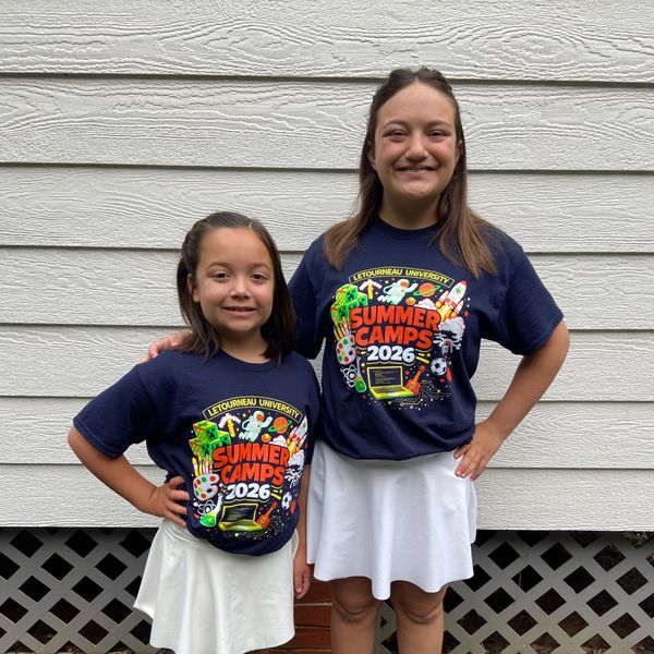 Two girls wearing matching summer camp shirts and white skirts.