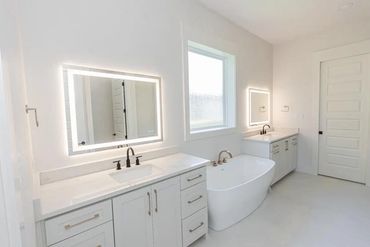 Bright modern bathroom with dual vanities and a freestanding bathtub.