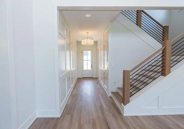 Bright hallway with wood flooring and modern staircase.
