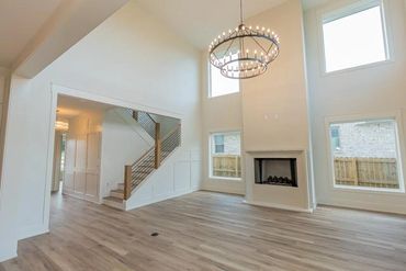 Bright, spacious living room with high ceilings and modern chandelier.