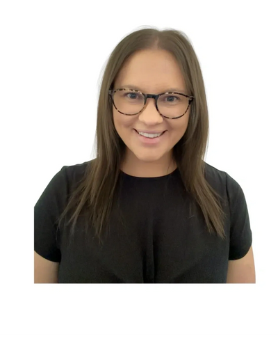 Smiling woman with glasses and long hair in a black top.