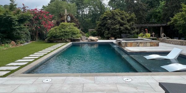 Modern backyard pool with clear water and lounge chairs. Cherokee County Pools