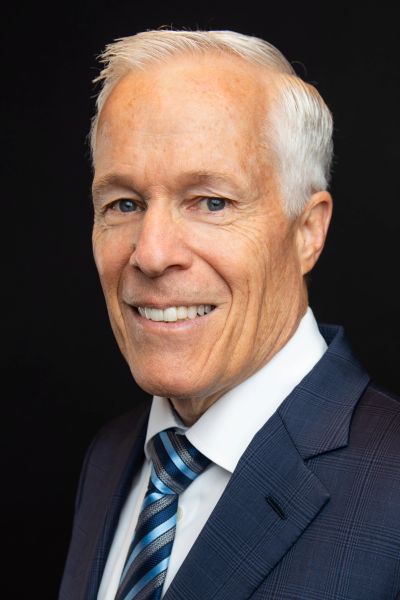 Smiling elderly man in suit and tie.