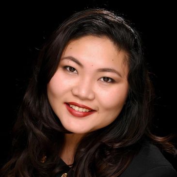 Portrait of a smiling woman with dark hair and red lipstick.