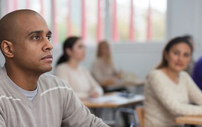 Focused adult students attentively listening in a classroom.
