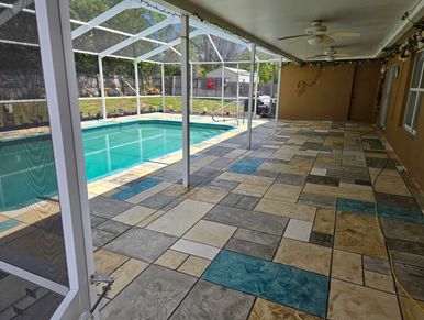 Covered patio with tile flooring next to a swimming pool.