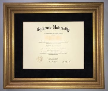 University diploma framed in a 2" wide gold frame with a black mat and gold fillet.